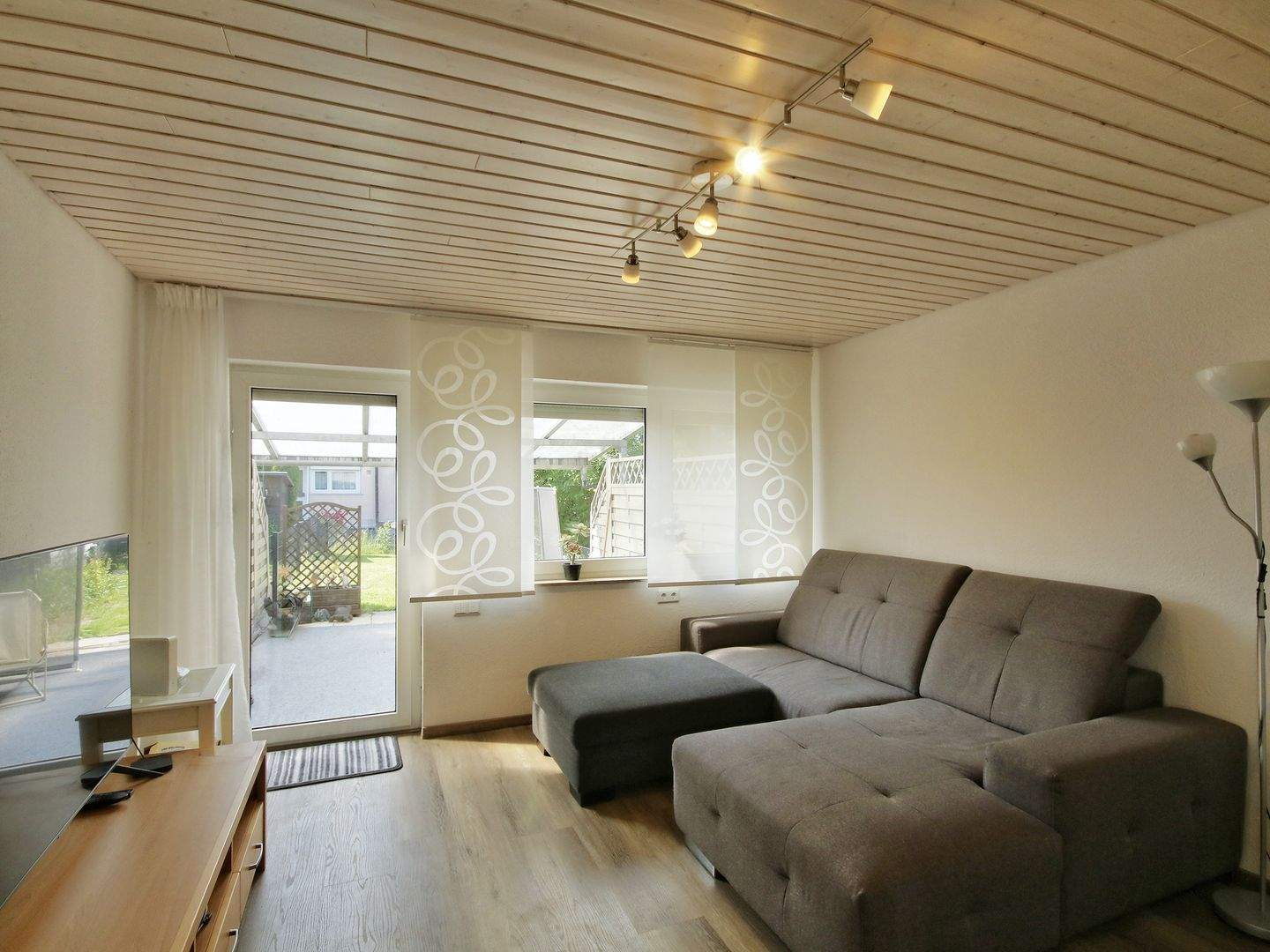 Helles Wohnzimmer mit großer Fensterfront zum Garten