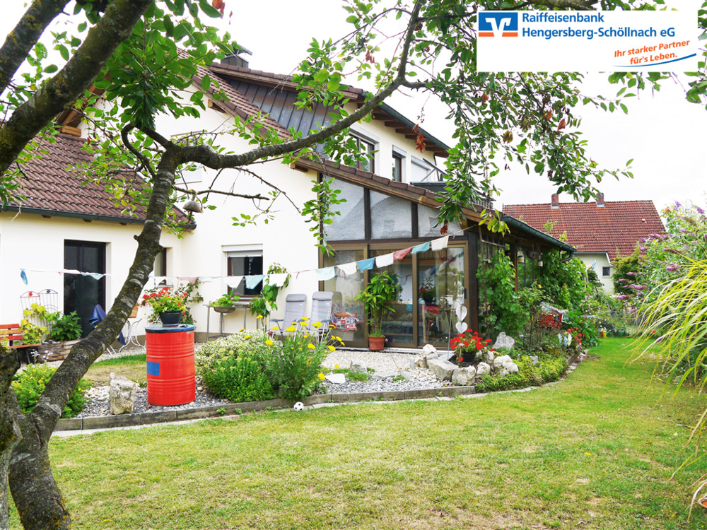 Hausansicht mit Wintergarten und Garten