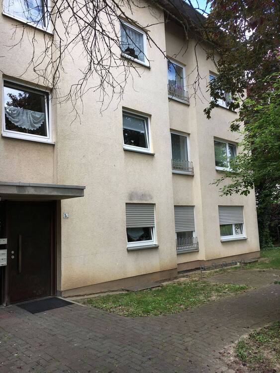 Gebäude Vorderseite des mehrstöckigen Wohnhauses umgeben von Grünanlagen mit Bäumen